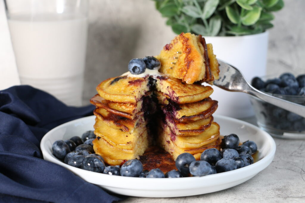 Lemon blueberry pancakes made with quinoa served with glass of milk
